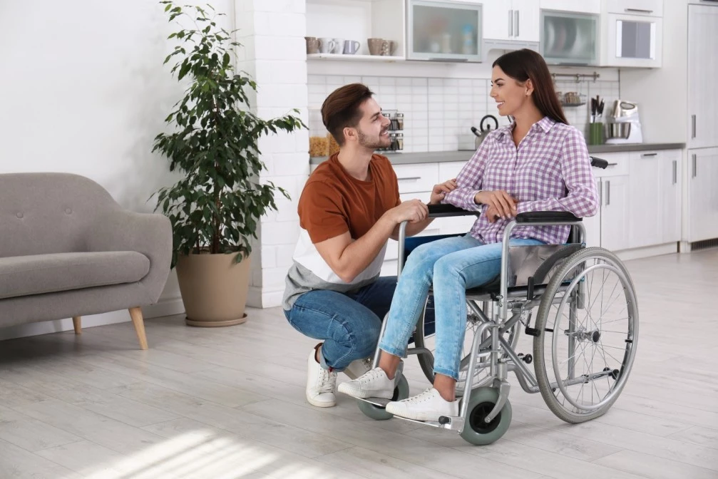 Support worker with disabled woman in wheelchair both smiling