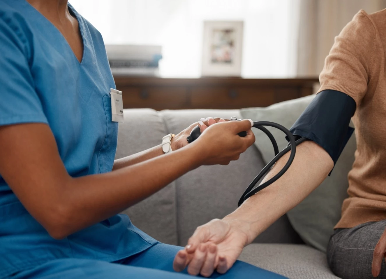 Nurse taking blood pressure of participant at home