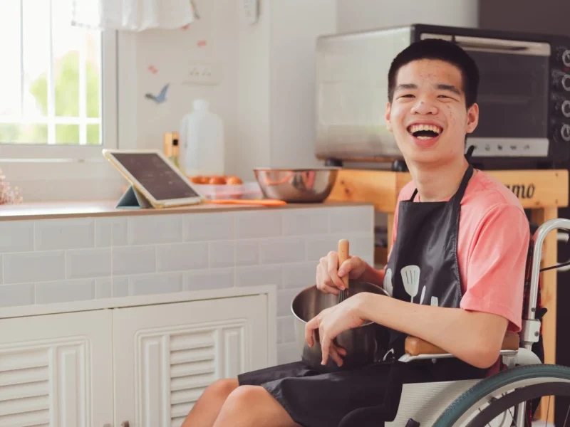 Happy disabled boy in wheelchair smiling at camera